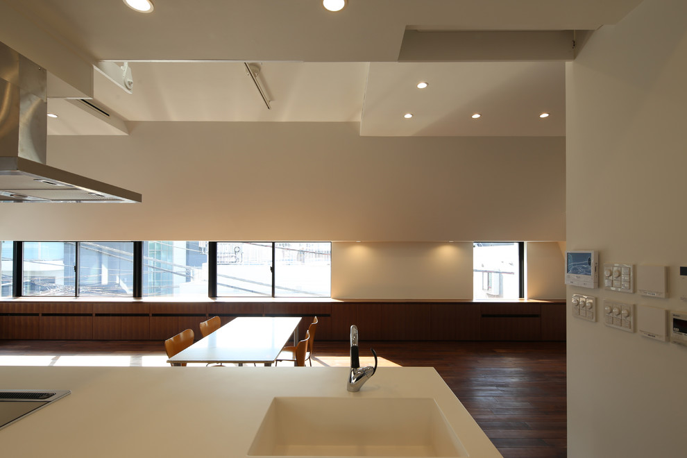 This is an example of a large modern open plan dining room in Tokyo with dark hardwood flooring, brown floors, white walls, no fireplace and a plastered fireplace surround.
