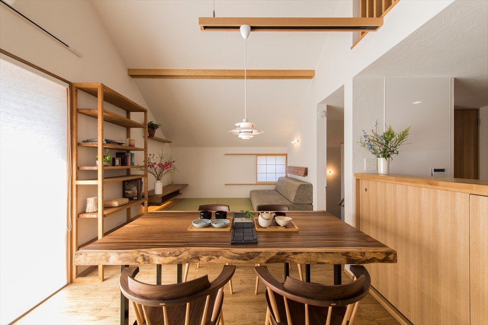 Ejemplo de comedor de estilo zen abierto con paredes blancas, suelo de madera en tonos medios y suelo marrón