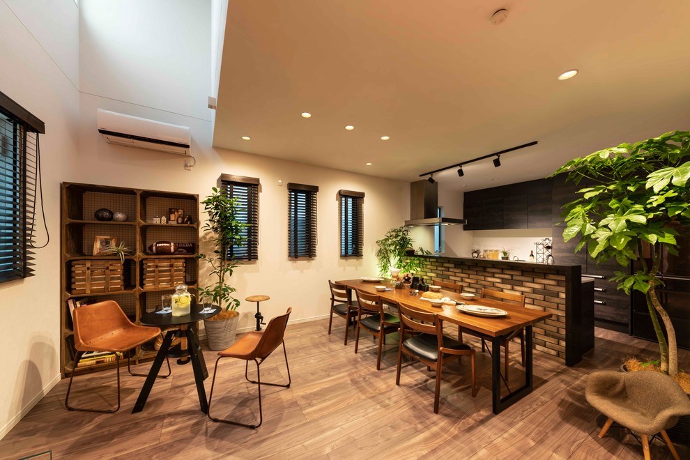 На фото: кухня-столовая среднего размера в стиле модернизм с красными стенами, полом из фанеры, двусторонним камином, фасадом камина из плитки и коричневым полом