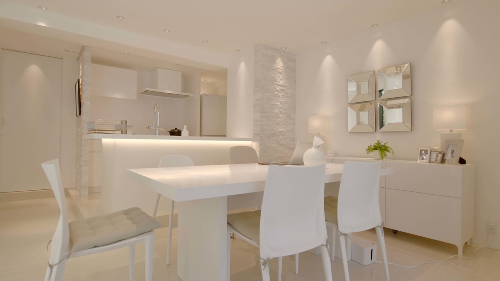 Aménagement d'une salle à manger ouverte sur le salon moderne avec un mur blanc et un sol blanc.