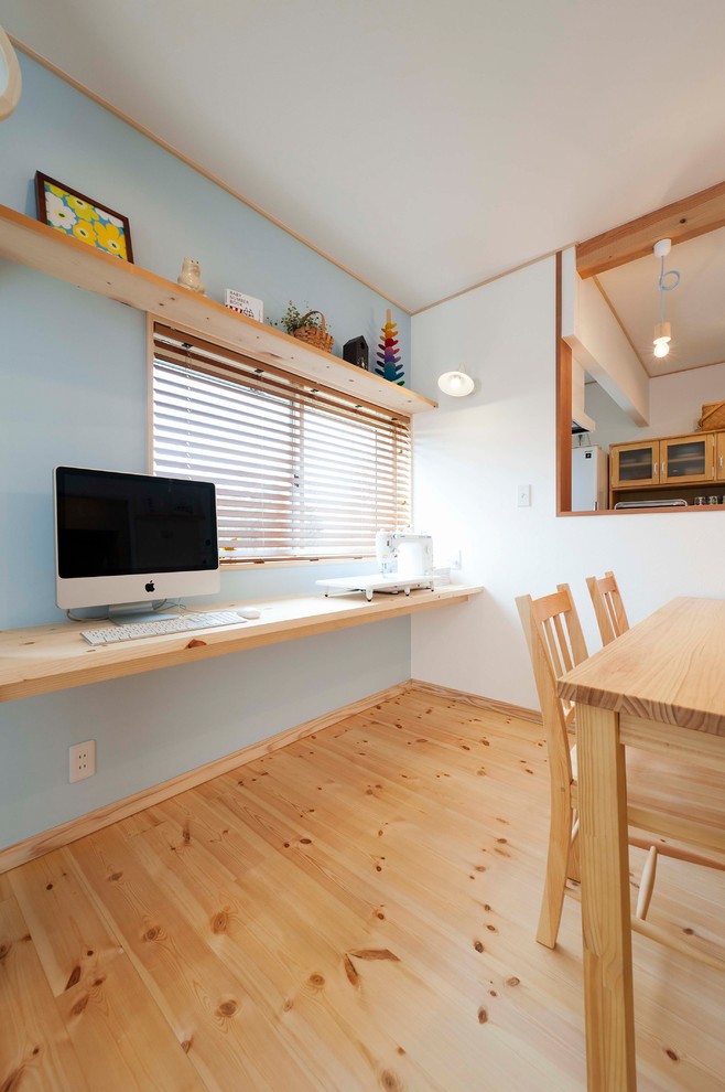 Стильный дизайн: столовая в скандинавском стиле с синими стенами, светлым паркетным полом и коричневым полом - последний тренд