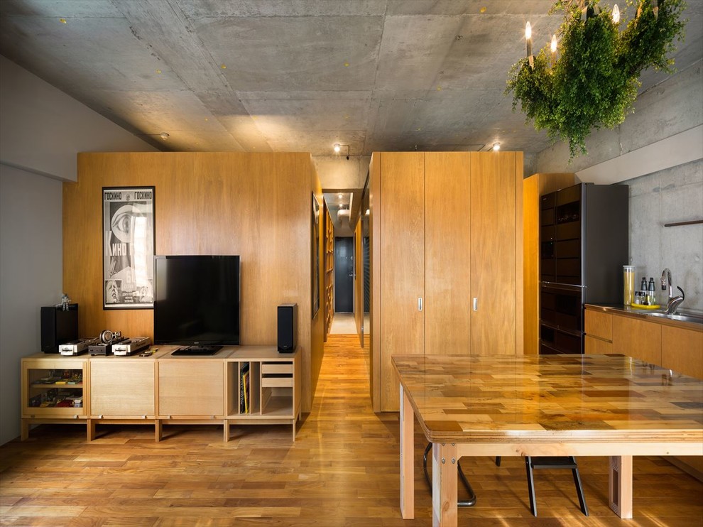 Idee per una sala da pranzo industriale con pareti grigie, pavimento in legno massello medio e pavimento marrone