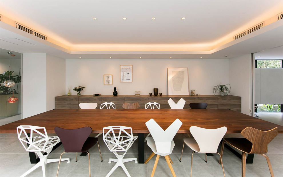 Photo of a contemporary open plan dining room with white walls, no fireplace and grey floors.