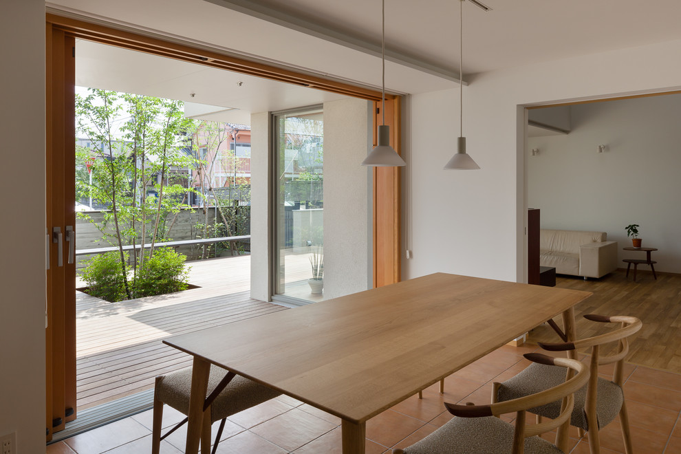 Ispirazione per una sala da pranzo aperta verso il soggiorno etnica con pareti bianche, pavimento in legno massello medio e pavimento marrone