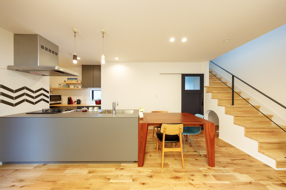 Exempel på en mellanstor minimalistisk matplats med öppen planlösning, med vita väggar, mellanmörkt trägolv och brunt golv