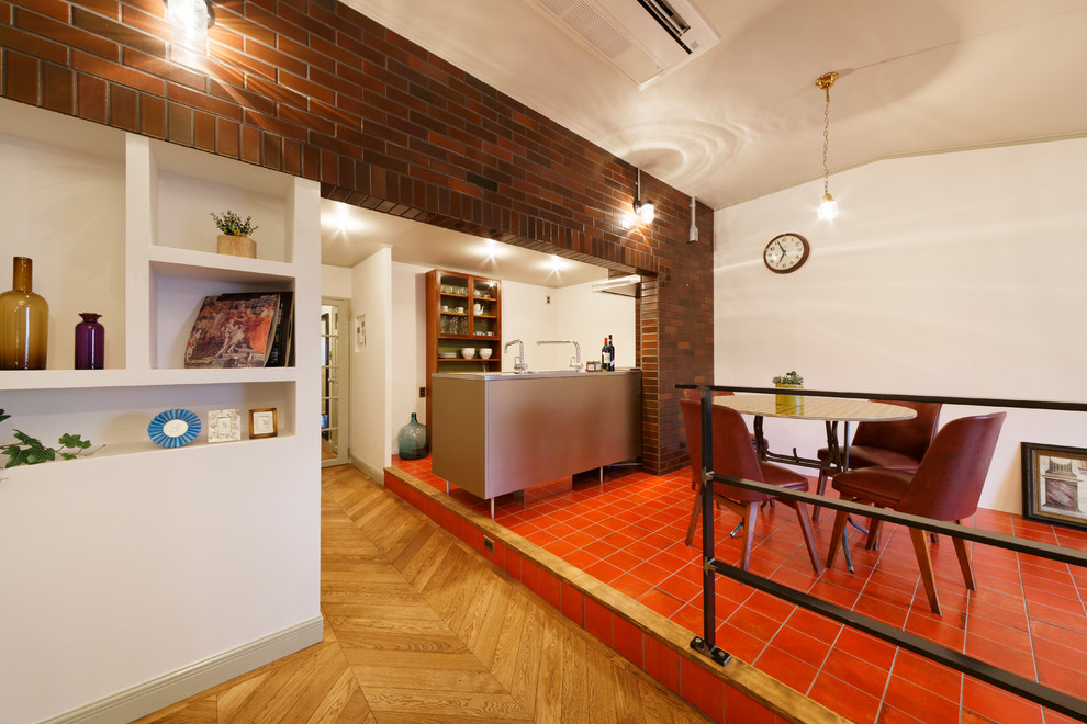 Immagine di una sala da pranzo aperta verso il soggiorno moderna con pareti bianche e pavimento rosso