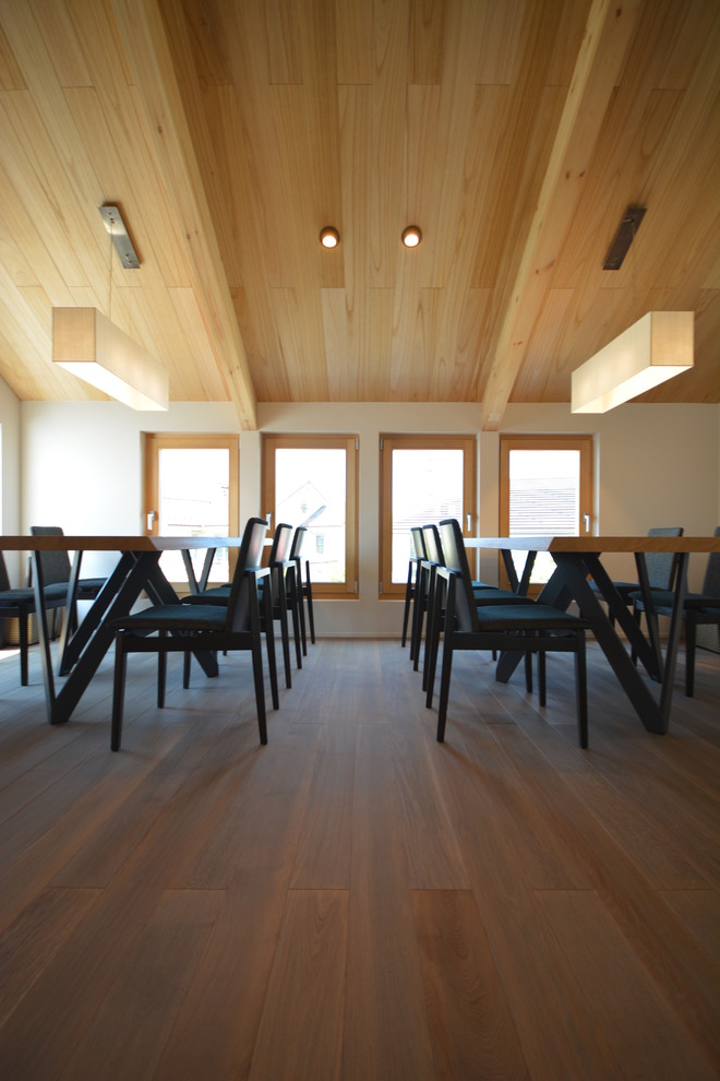 Inspiration pour une salle à manger minimaliste avec un mur blanc, un sol en contreplaqué et un sol gris.