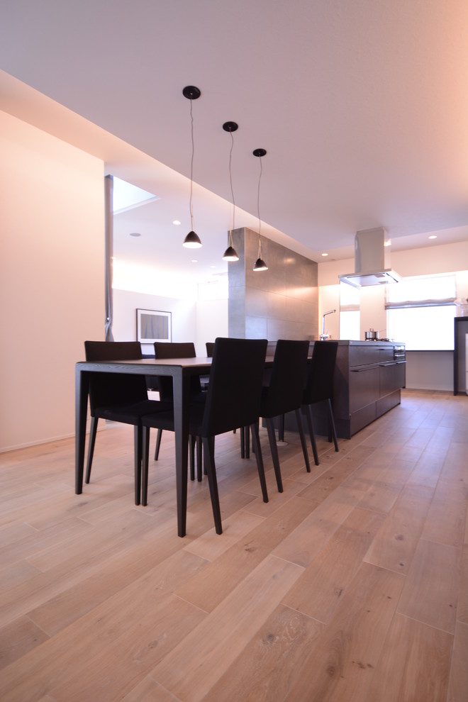 Moderne Wohnküche ohne Kamin mit weißer Wandfarbe, hellem Holzboden und weißem Boden in Sonstige