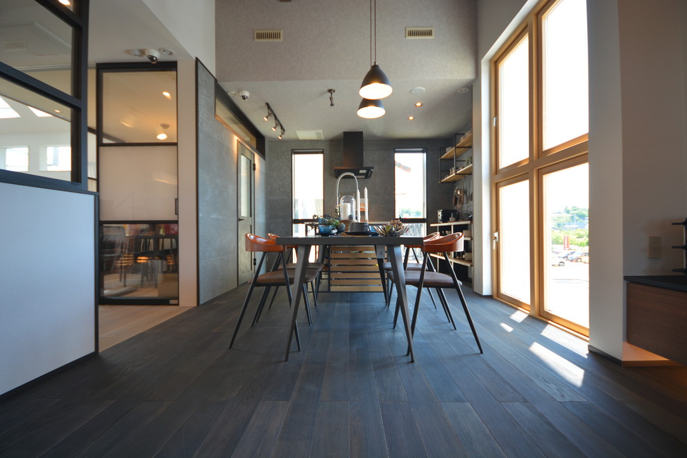 Immagine di una sala da pranzo industriale con pareti bianche, parquet scuro, nessun camino e pavimento nero