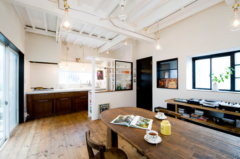 Foto di una sala da pranzo eclettica con pareti bianche, pavimento in legno massello medio e pavimento marrone