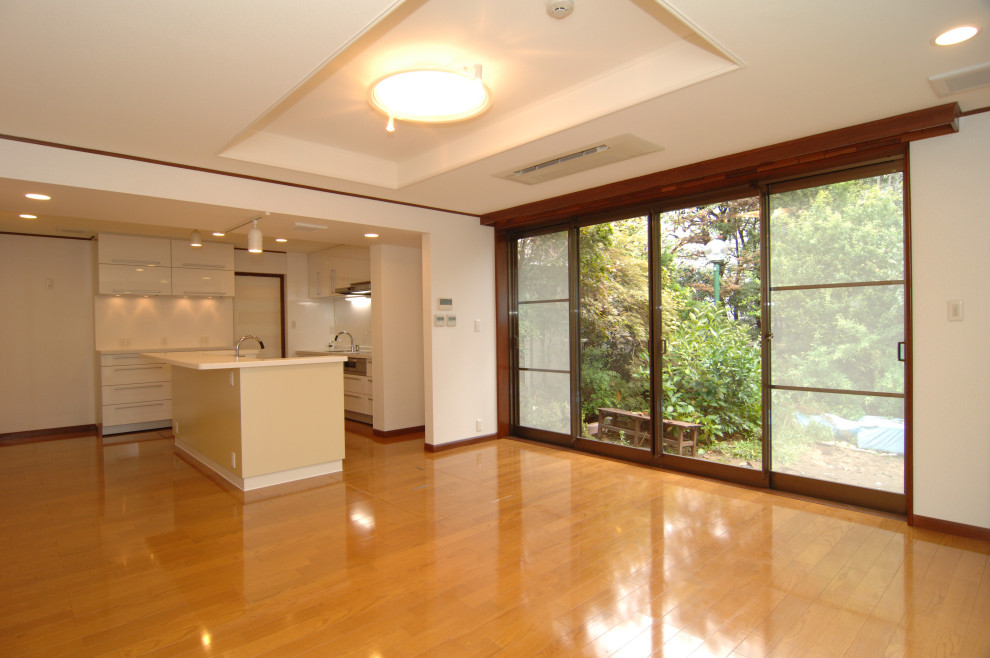 На фото: кухня-столовая среднего размера в стиле модернизм с белыми стенами, полом из фанеры и коричневым полом с