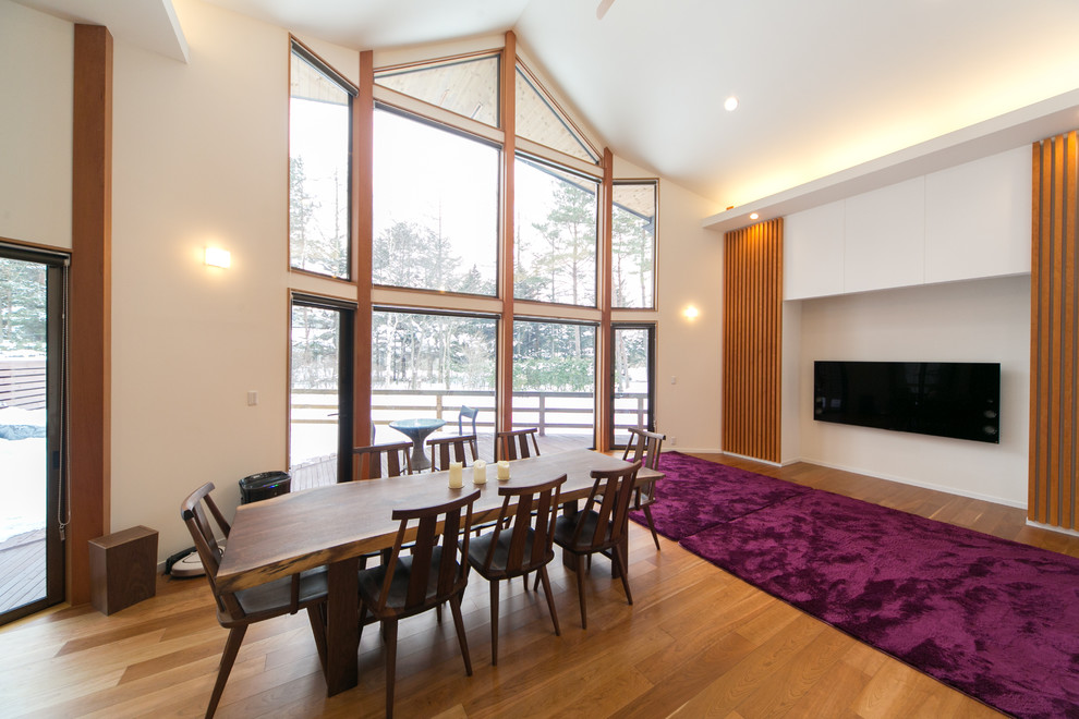 Inspiration for a timeless medium tone wood floor and brown floor dining room remodel in Other with white walls