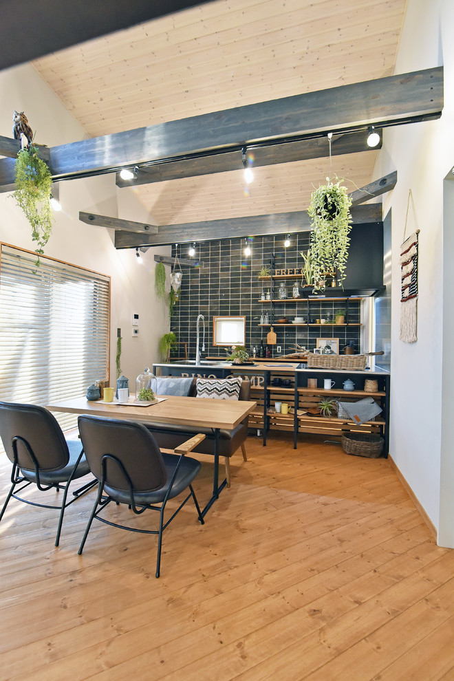 Idee per una sala da pranzo aperta verso il soggiorno stile rurale con pareti bianche, pavimento in legno massello medio e pavimento marrone