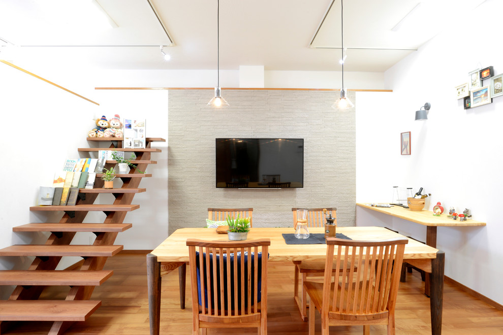 Idée de décoration pour une salle à manger asiatique avec un mur blanc et un sol en bois brun.