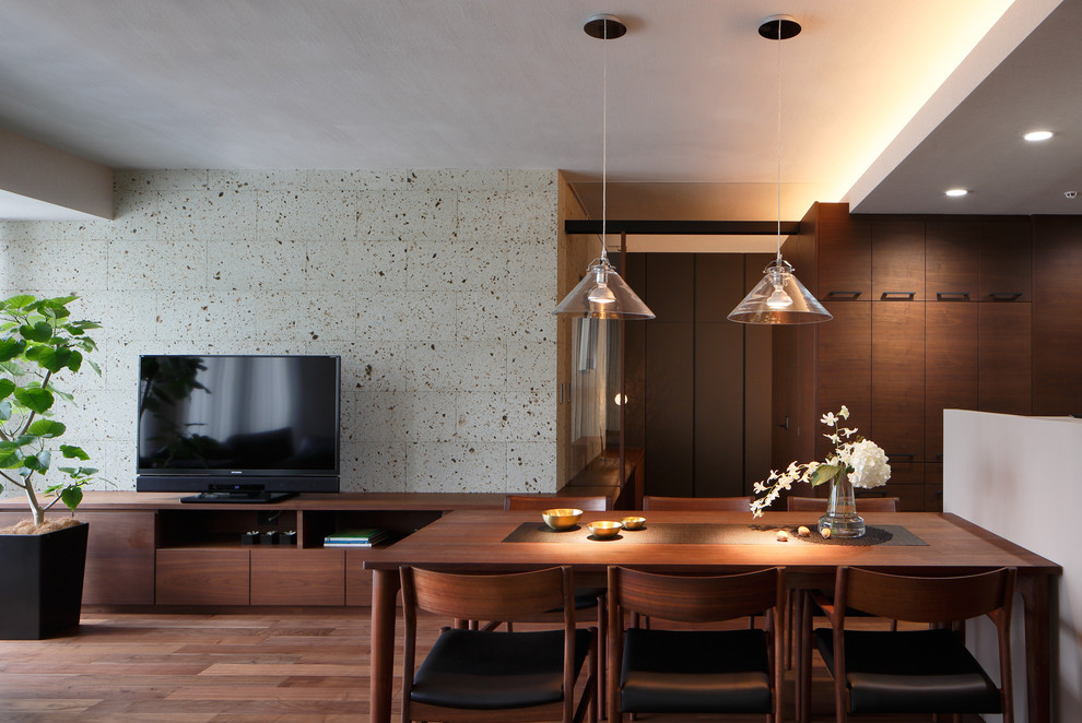 Imagen de comedor moderno abierto con paredes grises y suelo de madera en tonos medios