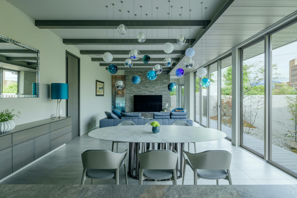Стильный дизайн: гостиная-столовая в современном стиле с белыми стенами, серым полом и балками на потолке - последний тренд