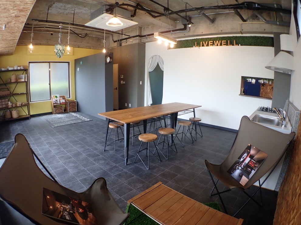 Foto di una sala da pranzo aperta verso il soggiorno industriale di medie dimensioni con pavimento nero e pareti multicolore