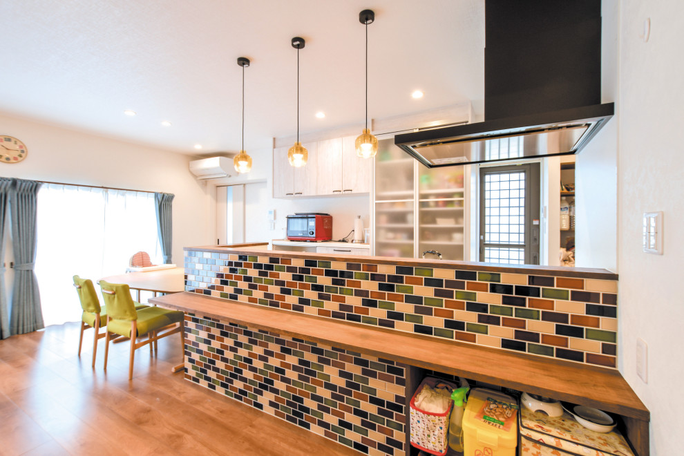 Réalisation d'une petite salle à manger ouverte sur le salon design avec un mur blanc, un sol en contreplaqué, aucune cheminée et un sol marron.