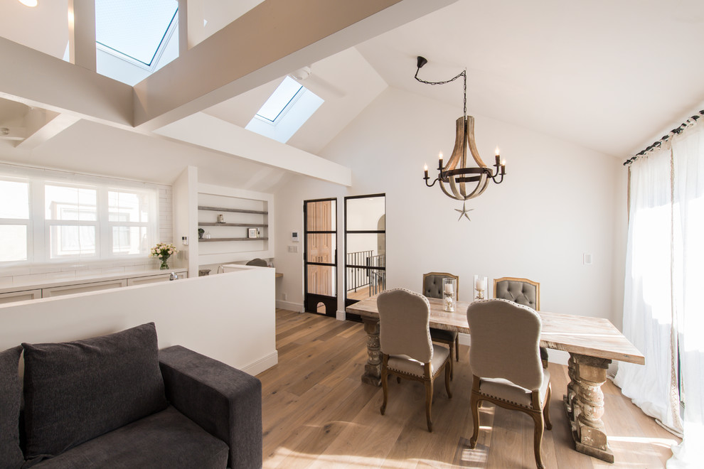 Cette photo montre une salle à manger chic avec un mur blanc, parquet peint et un sol marron.