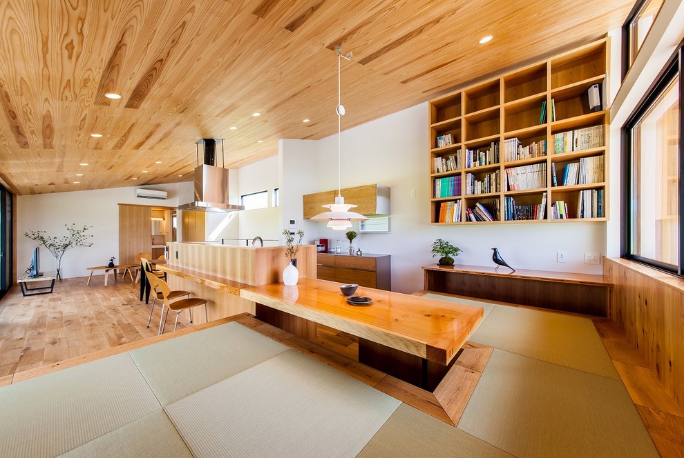 Exemple d'une salle à manger ouverte sur le salon tendance avec un mur blanc, un sol de tatami et un sol vert.