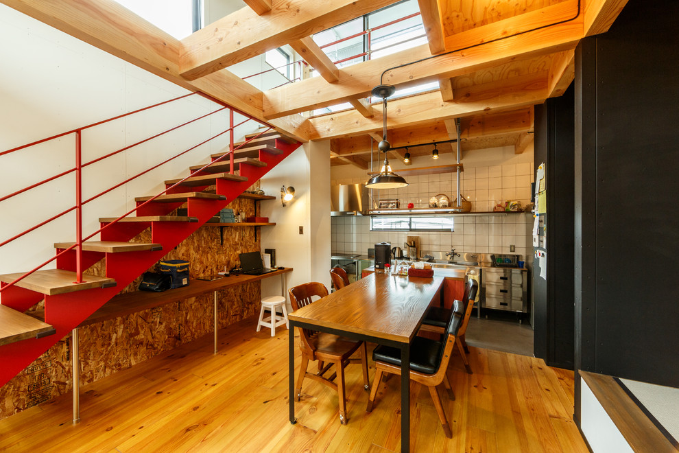 Immagine di una sala da pranzo aperta verso il soggiorno industriale con pareti bianche e pavimento in legno massello medio