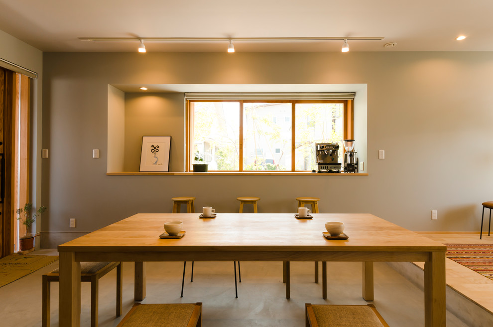 Idée de décoration pour une salle à manger ouverte sur la cuisine design de taille moyenne avec un mur gris, sol en béton ciré, aucune cheminée et un sol gris.