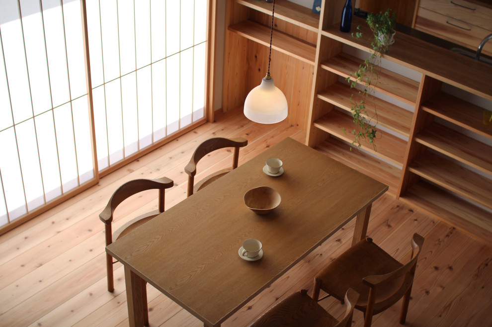 Aménagement d'une salle à manger ouverte sur le salon moderne de taille moyenne avec un mur blanc, un sol en bois brun et un sol marron.