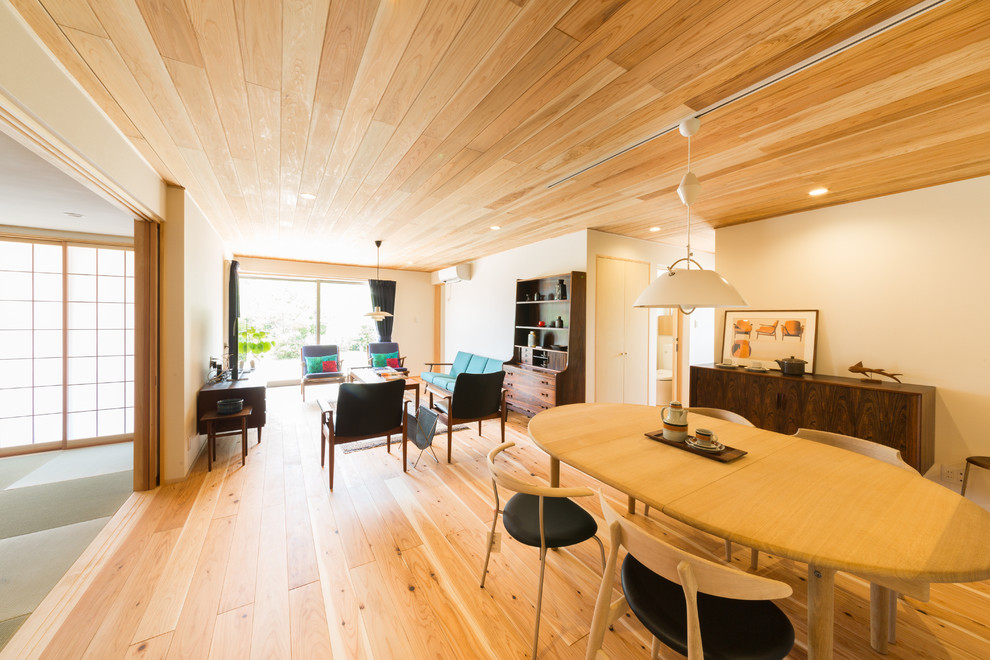 Esempio di una sala da pranzo aperta verso il soggiorno etnica con parquet chiaro e pavimento marrone