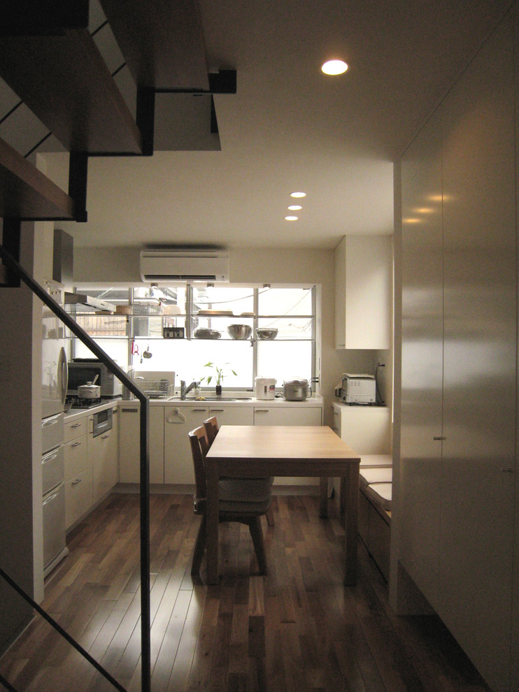 Exemple d'une petite salle à manger ouverte sur le salon moderne avec un mur blanc, un sol en bois brun et un sol marron.
