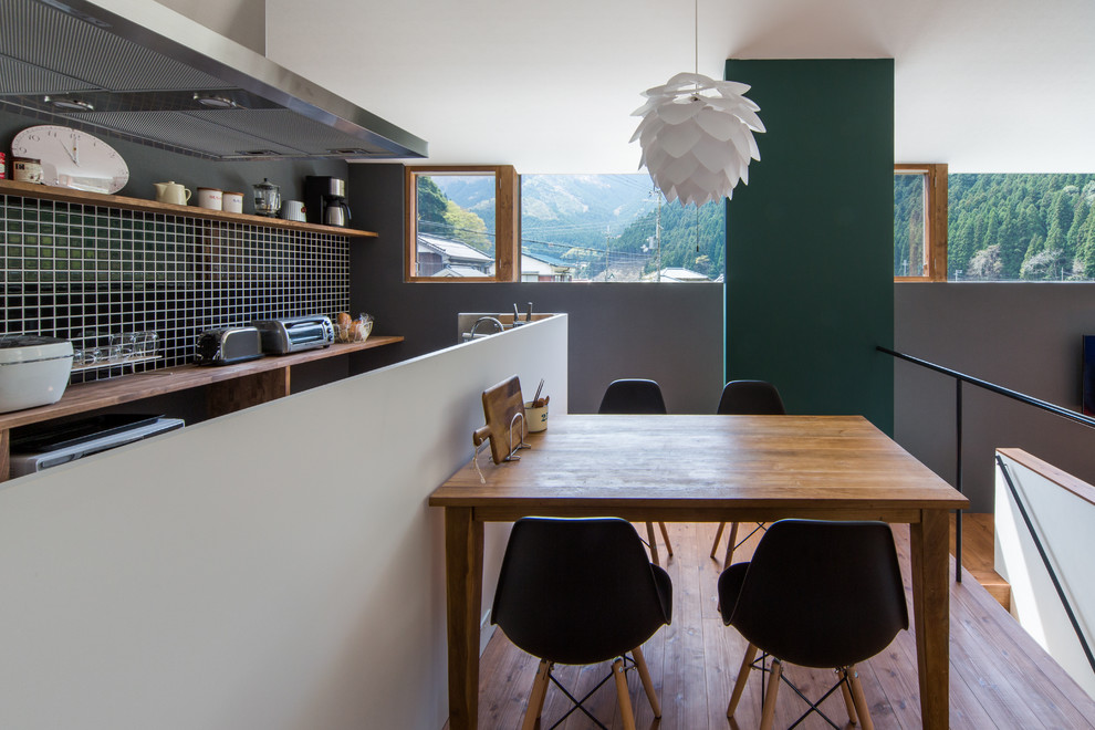 Inredning av en minimalistisk liten matplats med öppen planlösning, med vita väggar och mellanmörkt trägolv
