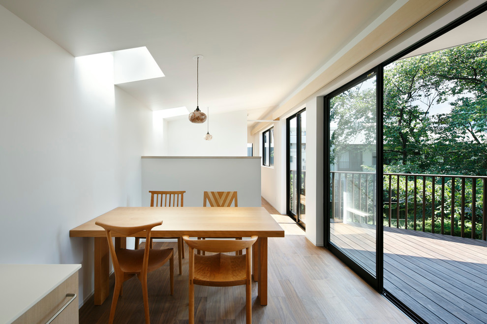 На фото: кухня-столовая среднего размера в современном стиле с белыми стенами и паркетным полом среднего тона без камина