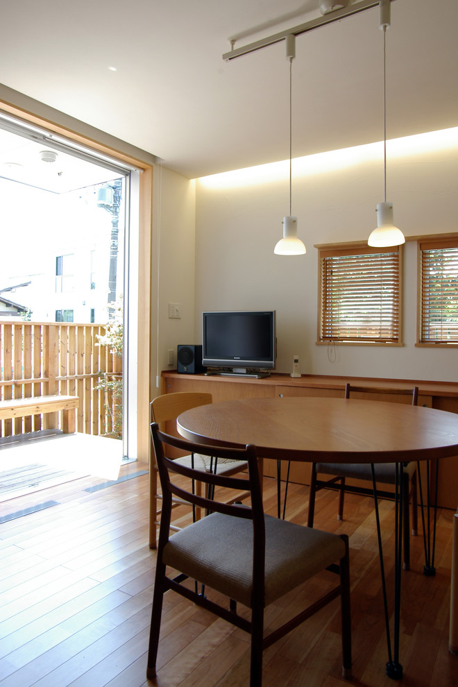 Esempio di una sala da pranzo aperta verso la cucina contemporanea di medie dimensioni con pareti bianche, parquet scuro, nessun camino e pavimento marrone