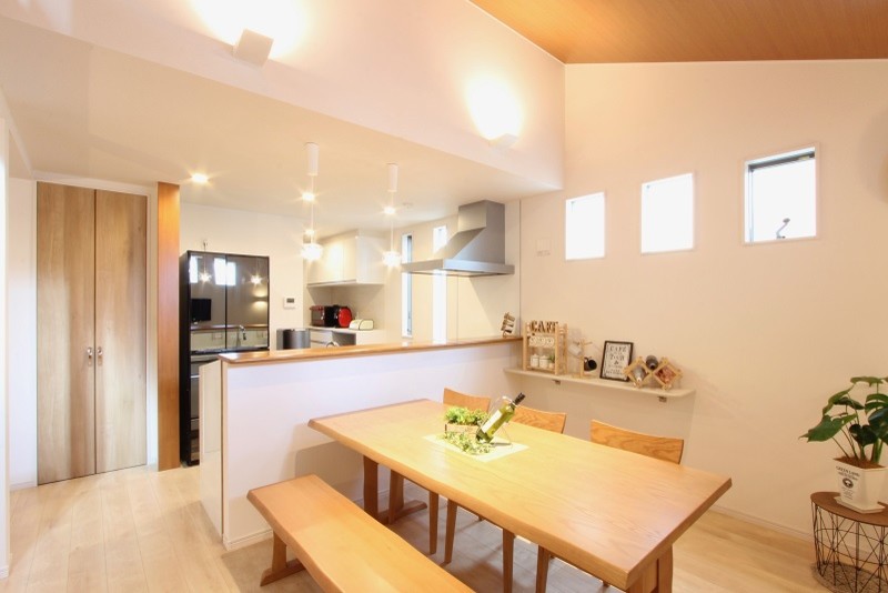 На фото: большая кухня-столовая в современном стиле с белыми стенами, полом из фанеры, бежевым полом и деревянным потолком