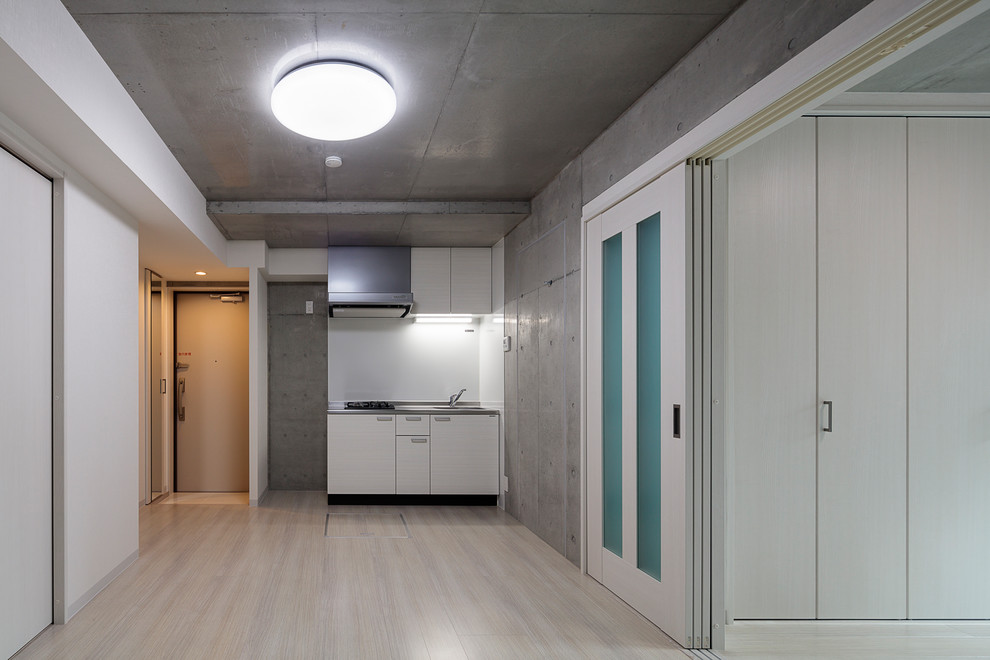Idee per una sala da pranzo aperta verso la cucina minimalista di medie dimensioni con pavimento in compensato, pavimento bianco e pareti multicolore