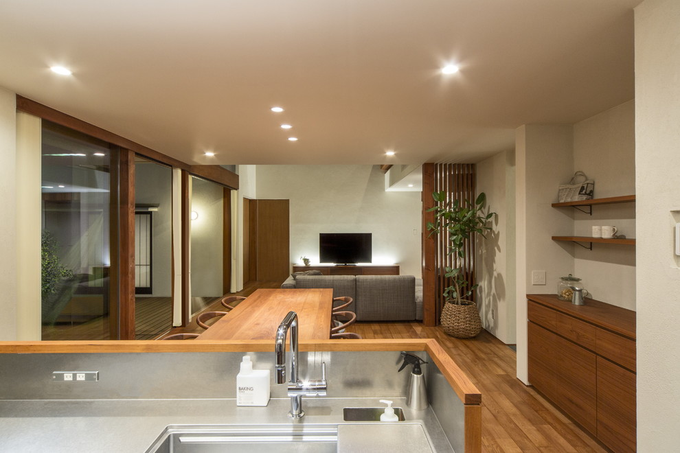 На фото: гостиная-столовая в стиле модернизм с белыми стенами, паркетным полом среднего тона и коричневым полом
