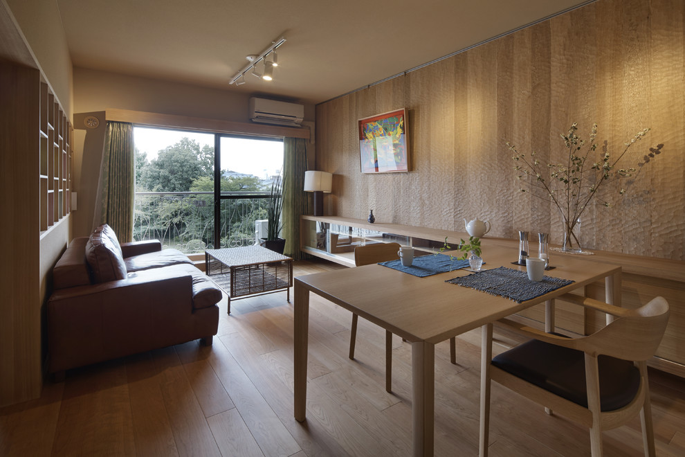 Modelo de comedor minimalista abierto con paredes beige y suelo de madera clara