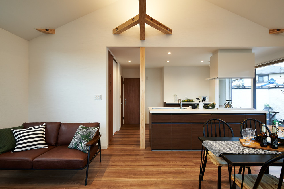 Imagen de comedor retro abierto con paredes blancas, suelo de madera en tonos medios y suelo marrón