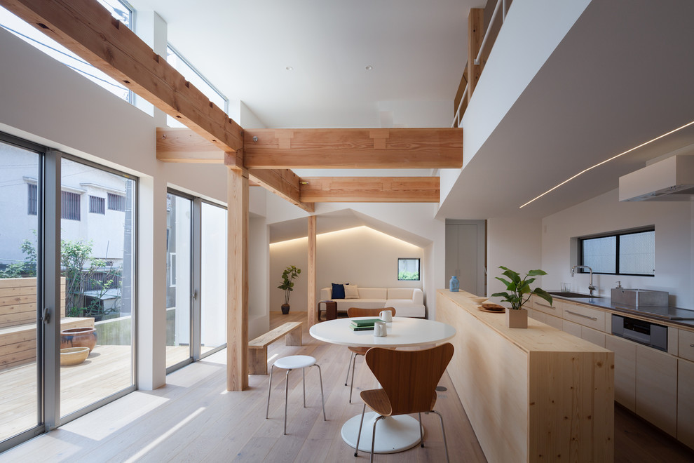 Ispirazione per una sala da pranzo aperta verso il soggiorno nordica con pareti bianche e pavimento in legno massello medio