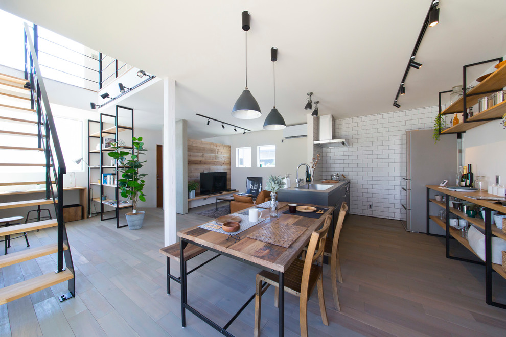 Idee per una sala da pranzo aperta verso il soggiorno industriale con pareti bianche, pavimento in legno verniciato e pavimento grigio