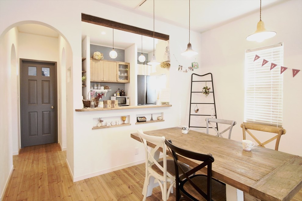 Idee per una sala da pranzo aperta verso la cucina scandinava con pareti bianche, pavimento in legno massello medio e nessun camino
