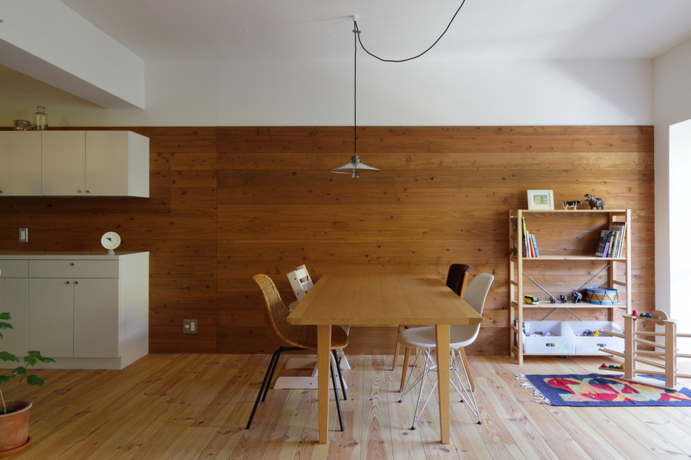 Ispirazione per una sala da pranzo aperta verso la cucina stile marinaro con parquet chiaro e pareti marroni