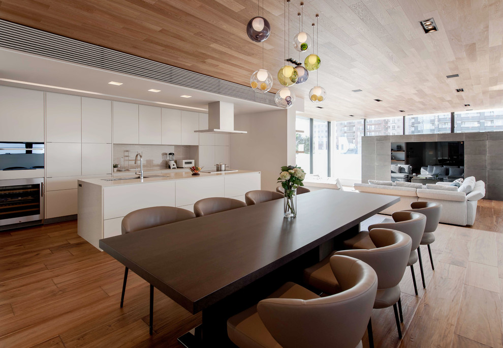 Réalisation d'une salle à manger ouverte sur le salon design de taille moyenne avec un mur blanc, un sol en bois brun et aucune cheminée.
