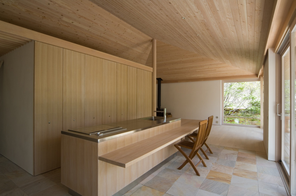 Exempel på ett modernt kök med matplats, med vita väggar, en öppen vedspis, en spiselkrans i sten och beiget golv