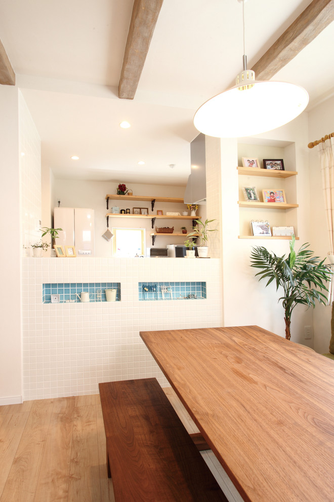 Foto di una sala da pranzo aperta verso la cucina shabby-chic style con pareti bianche, pavimento in compensato e pavimento beige