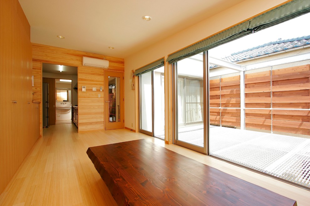 Idées déco pour une salle à manger ouverte sur le salon moderne avec un mur marron, parquet en bambou, aucune cheminée et un sol marron.
