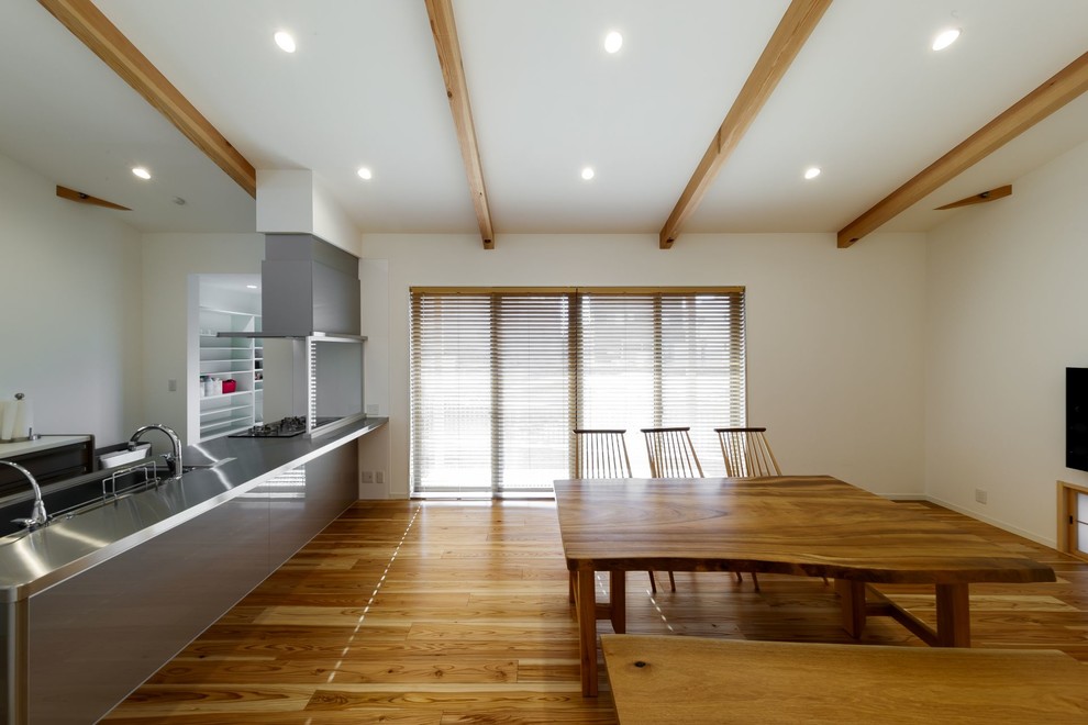 Mittelgroßes Asiatisches Esszimmer mit weißer Wandfarbe und braunem Holzboden in Sonstige
