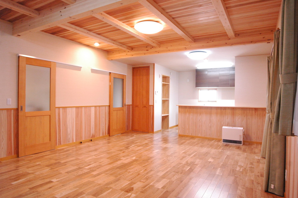 Immagine di una grande sala da pranzo aperta verso il soggiorno etnica con pareti beige, parquet chiaro, nessun camino e pavimento beige