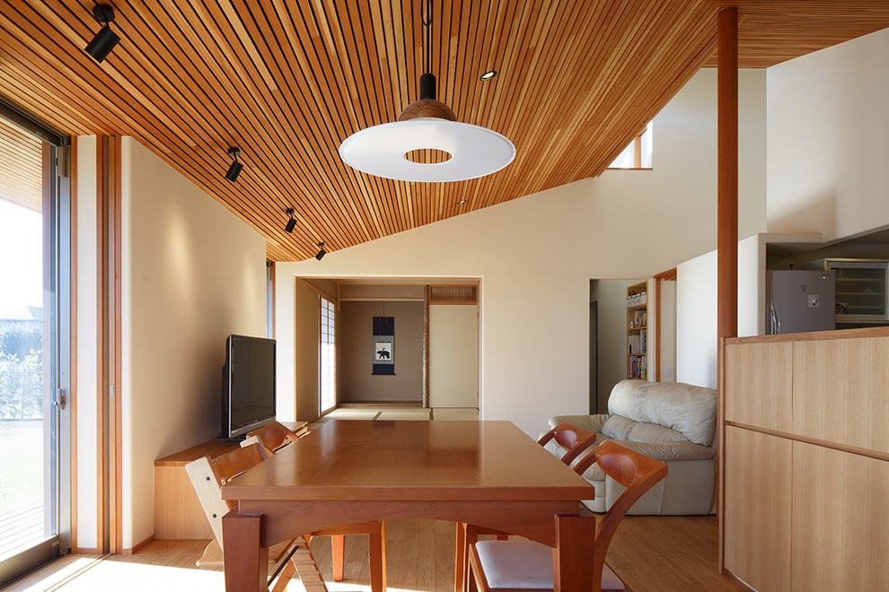 Imagen de comedor de estilo zen de tamaño medio abierto sin chimenea con paredes blancas, suelo de madera en tonos medios y suelo marrón