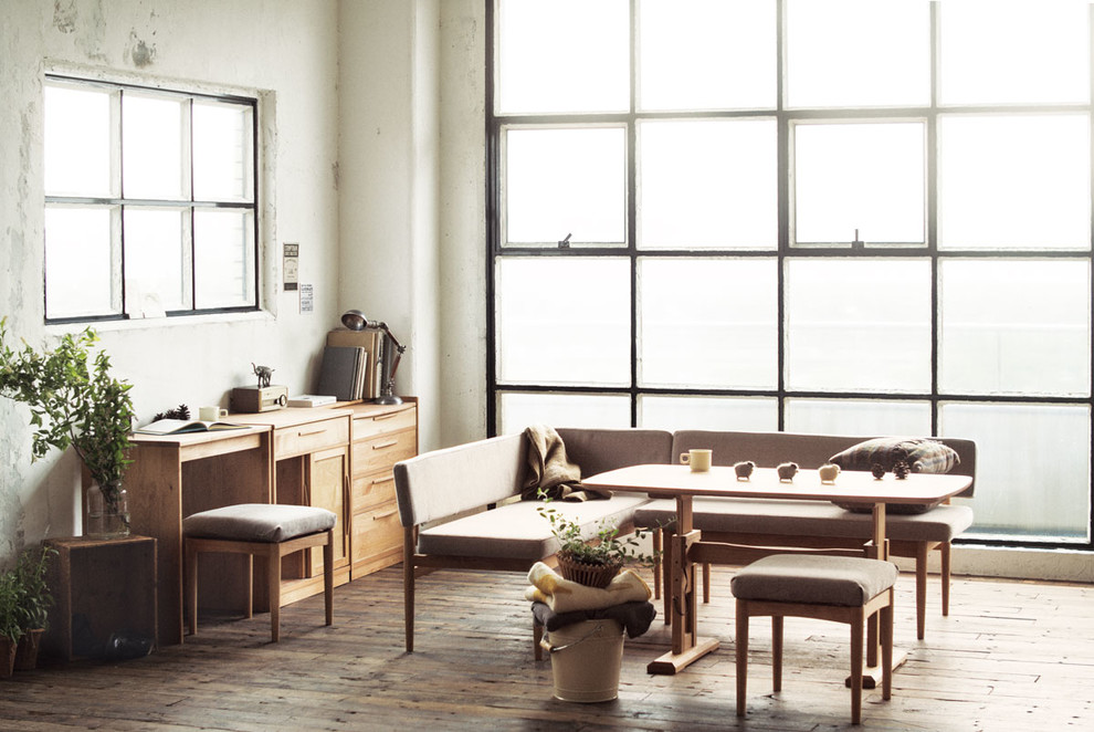 Foto di una sala da pranzo aperta verso il soggiorno scandinava con pareti grigie, pavimento in legno massello medio e pavimento marrone