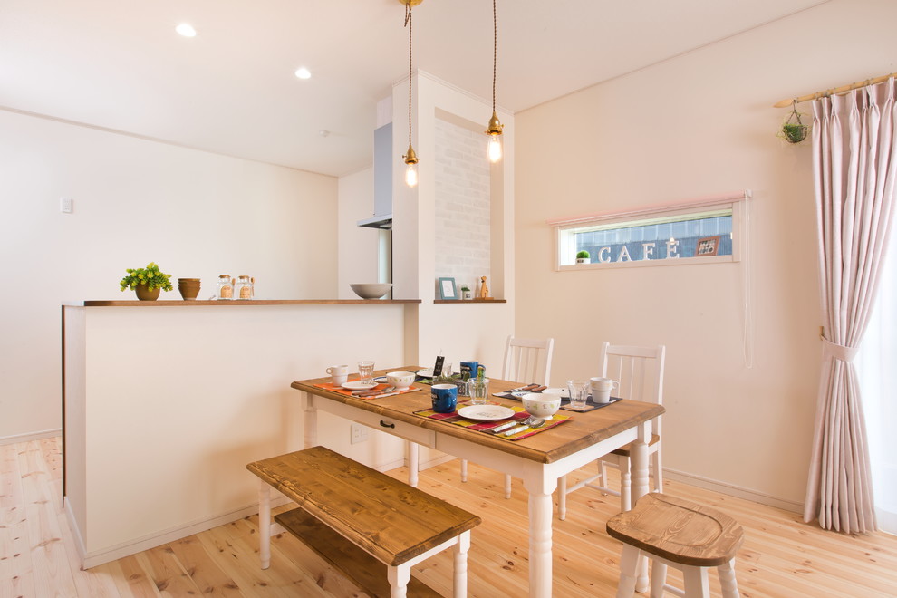Idee per una sala da pranzo aperta verso il soggiorno etnica con pareti bianche e parquet chiaro